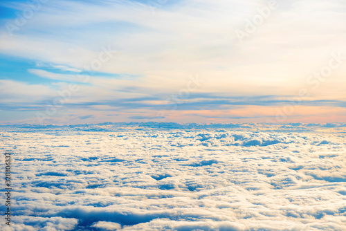 Aerial view of blue sunset sky with layers of white fluffy cumulus and cirrus clouds