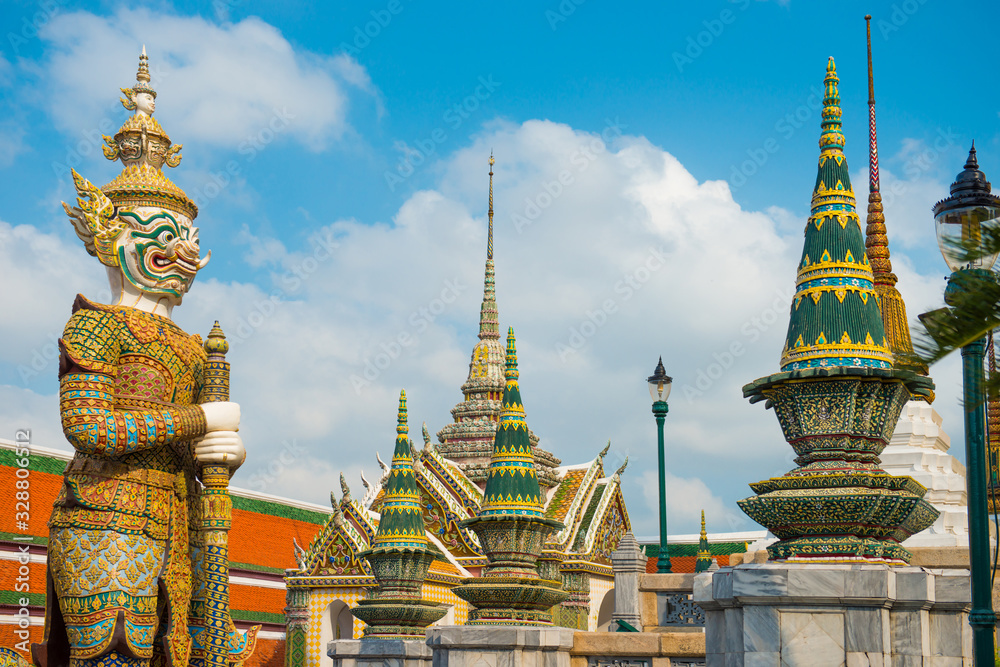 Fototapeta premium Statue of bright colored and gold decorated mythical demon guardian near gates in Grand Palace, Bangkok, Thailand