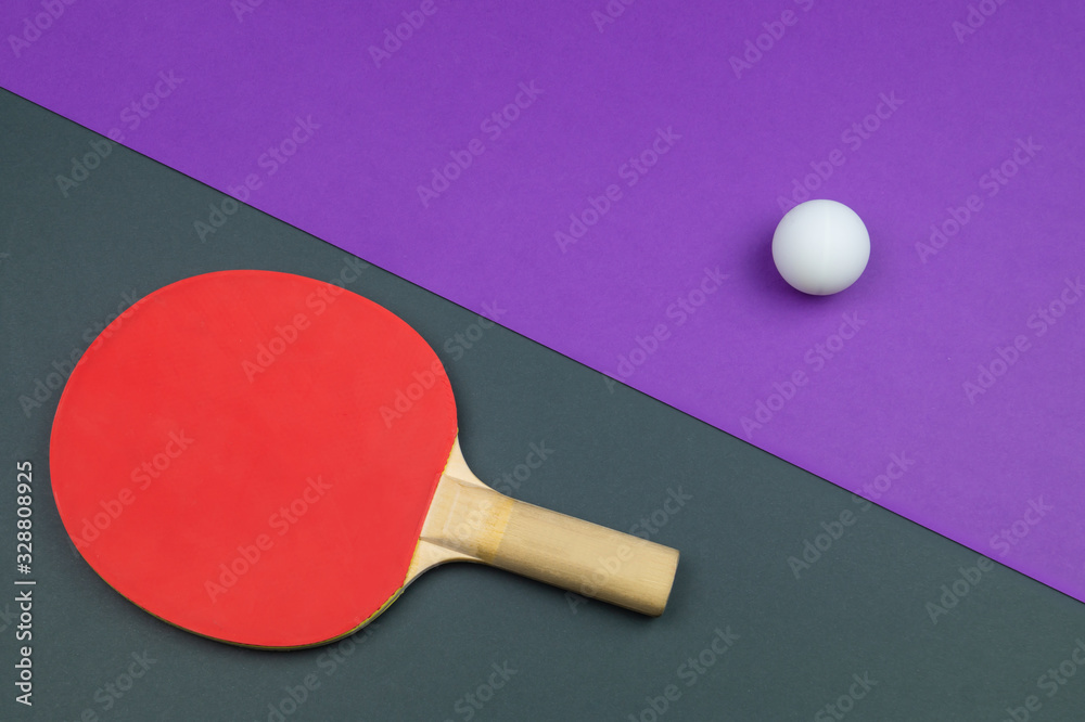 Red table tennis racket with a ball isolated on a colored background. sport equipment for ping pong Red table tennis racket with a ball isolated on a colored background. sport equipment for ping pong