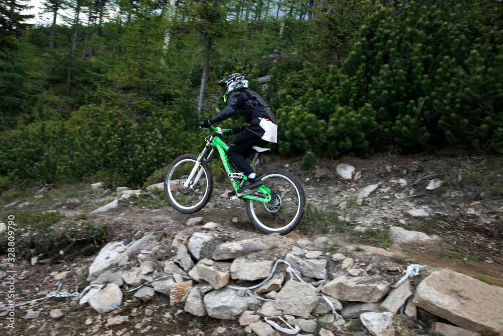 Fototapeta premium Biker at mountain rocky peak landscape Bike Park Czarna Gora Poland