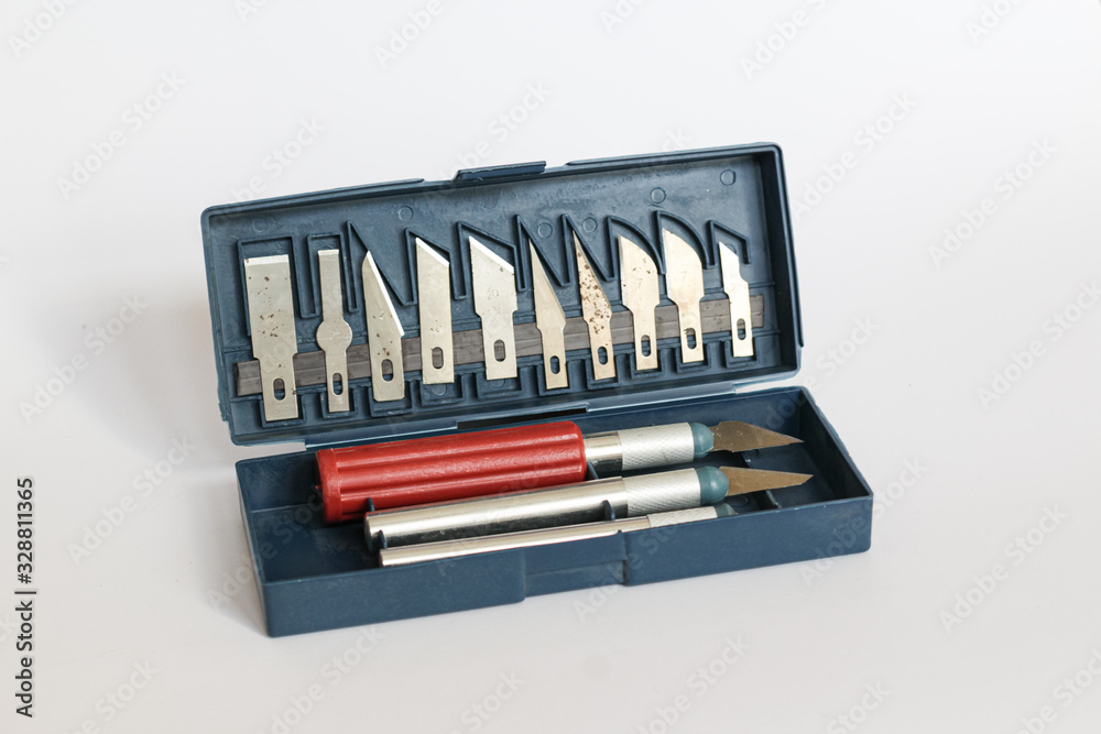 Tools for handmade, knives for cutting wood in a blue box on a gray background. Slightly rusty interchangeable knives. Tools for handmade, knives for cutting wood in a blue box on a gray background. Slightly rusty interchangeable knives.