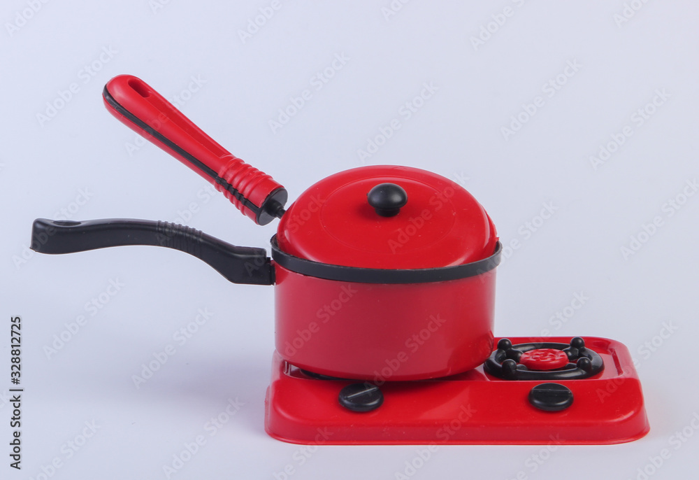 Naklejka premium Toy plastic stove with pan on a white background. Kid's Kitchen