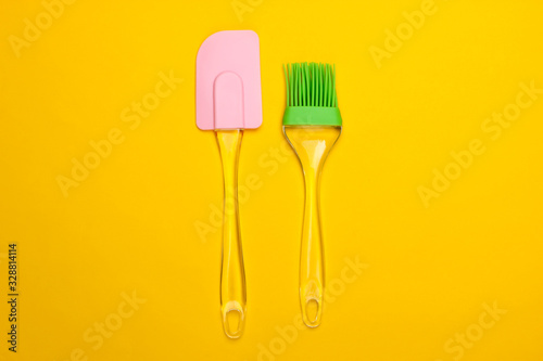 Kitchen tools. Kitchen spatula and brush on a yellow background. Minimalism. Top view