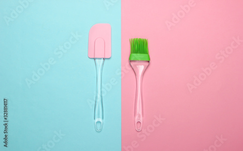 Kitchen tools. Kitchen spatula and brush on pink blue pastel background. Minimalism. Top view
