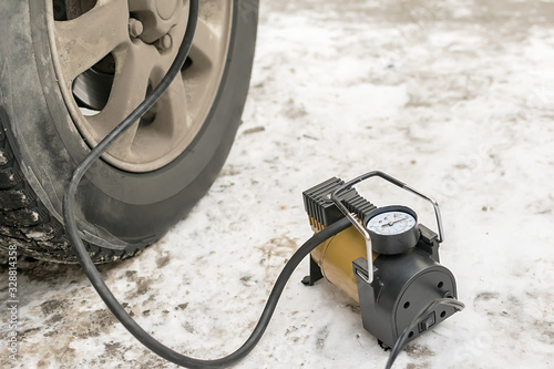 Cuadro en lienzo Pump, automobile compressor for inflating tires with air stands in the winter on