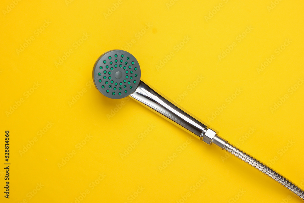 Shower head for the bathroom with hose on yellow background. Top view Shower head for the bathroom with hose on yellow background. Top view