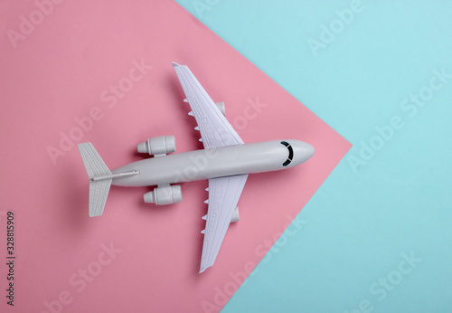 Toy model of plane on a blue-pink pastel background. The concept of tourism, air travel, minimalism. Top view
