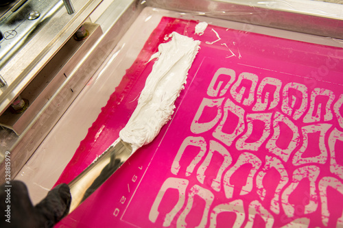 Spreading ink in a printing screen for screen printing t-shirts or posters photo