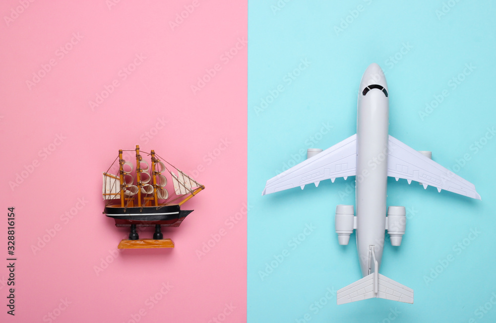 Fototapeta Flat lay travel design. Figurine of a ship, airplane on a blue-pink pastel background. Top view