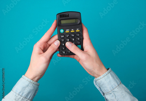Wallpaper Mural Female hands use calculator on a blue background. Top view Torontodigital.ca