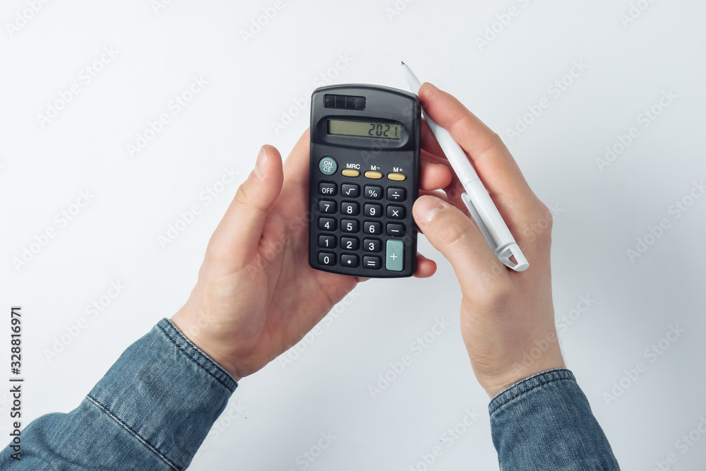 Male hands count on a calculator on white background Male hands count on a calculator on white background