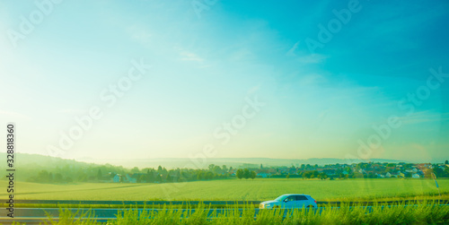 Germany, Frankfurt, Sunrise, a large green field with trees in the background