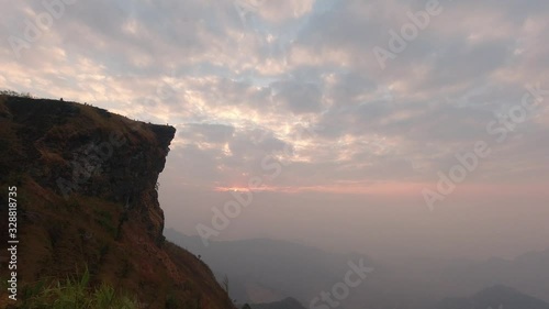 Time lapse of beautiful sunrise at Phu Chi Fah National Park, A tourist destination on a hilltop during the foggy and beautiful light in the morning and sunset in Chiang Rai Thailand 