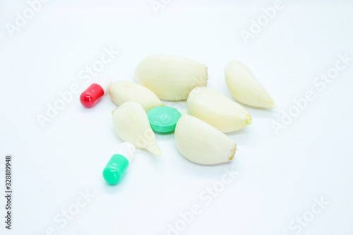 Garlic, vitamin pills, medicine located on a white background