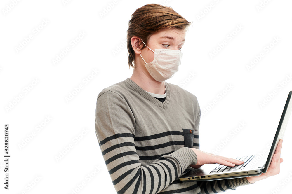 Isolate photo of Caucasian guy in medical mask with a laptop in his hands