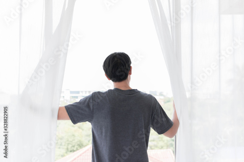 A man opens the window to see outside