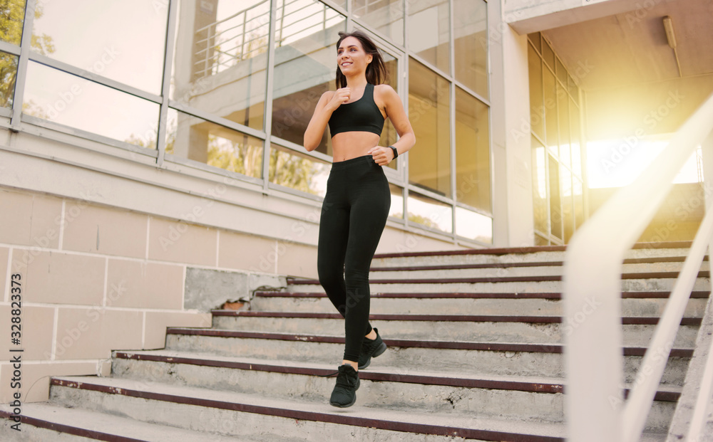 Attractive woman running down on stairs outdoors
