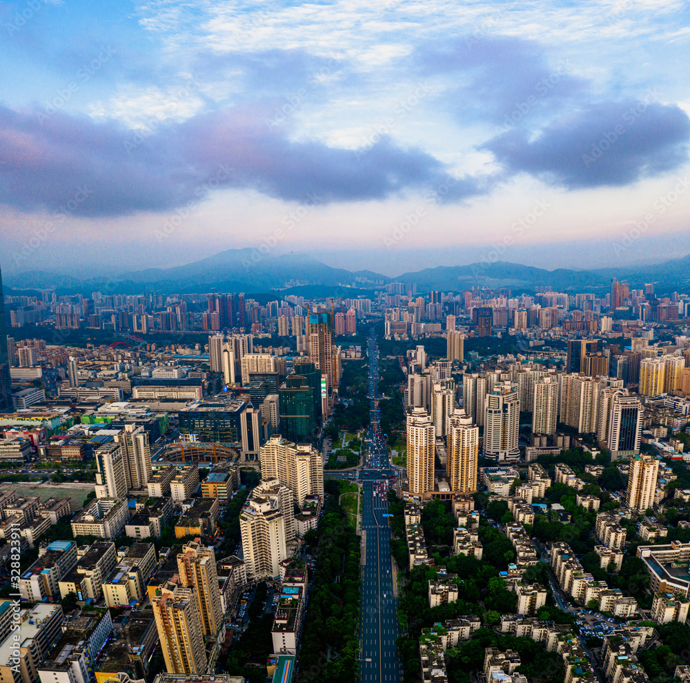 A vertically-merged aerial panorama, showcasing the sunset cityscape and cars waiting for green light on the road in downtown, China.