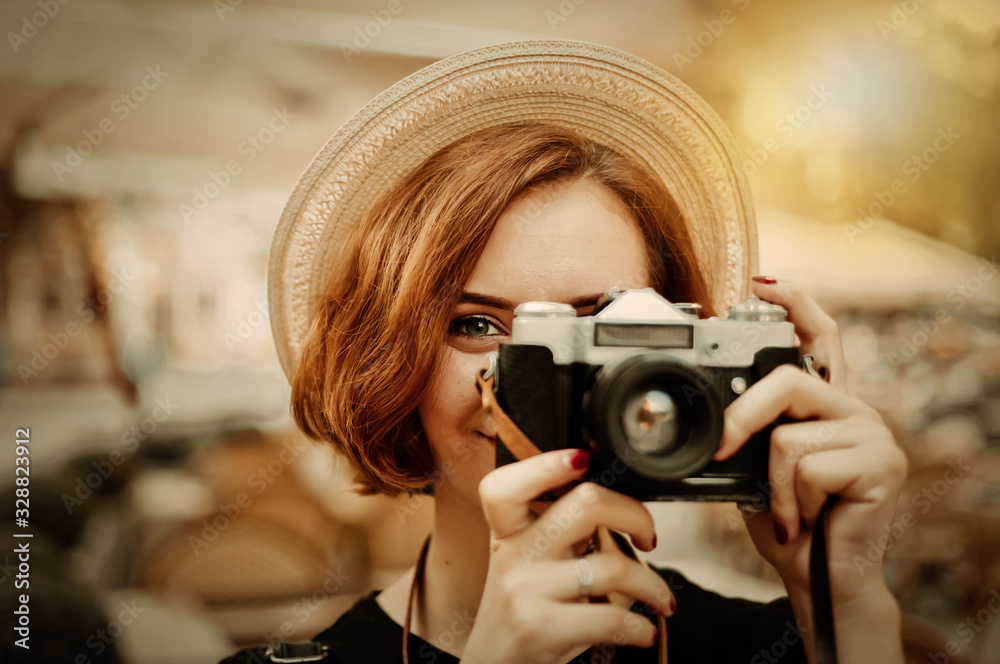 Smilling hipster woman holding a retro camera in her hands and taking a picture Smilling hipster woman holding a retro camera in her hands and taking a picture