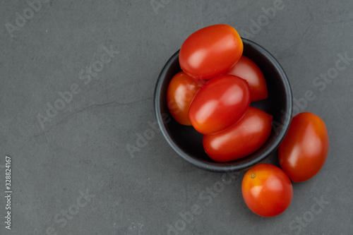 Cherry tomatoes in mini black bowl to prepare for cooking.