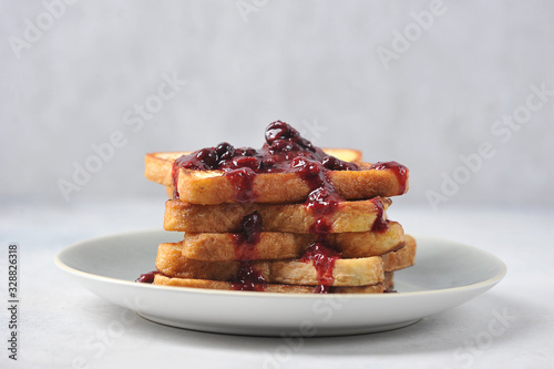 Toast with berry jam on a plate. Light background. Close-up. Free space for text.