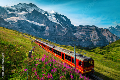 Electric passenger train and snowy Jungfrau mountains in background, Switzerland photo