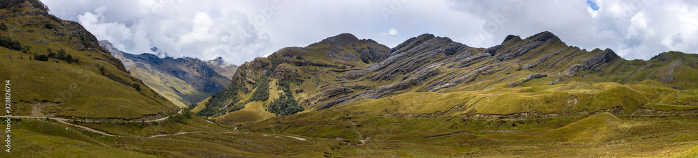 Panoramic view of an Andean landscape with sediment rocks and cloudscape in the background in Ancash Region, Peru