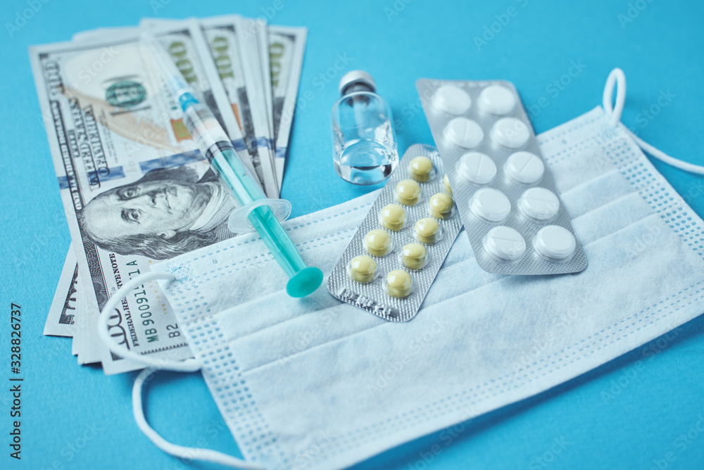 protective mask, medical items and dollar bills on the blue background. Expensive medicine concept. Pharmaceutical industry and medical insurance protective mask, medical items and dollar bills on the blue background. Expensive medicine concept. Pharmaceutical industry and medical insurance