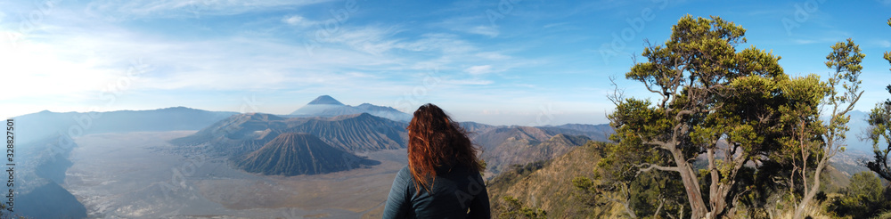 Beautiful woman with red hair watching over Mt Bromo volcano in Java Indonesia