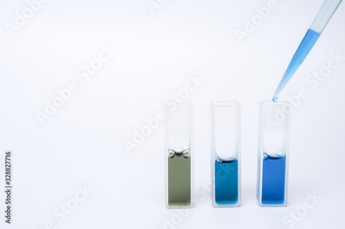 Adding blue reagent into the cuvette on isolated white background.
