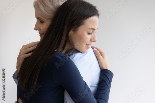 Quadro su tela Smiling senior mother and millennial girl child hug cuddle make peace reconcile
