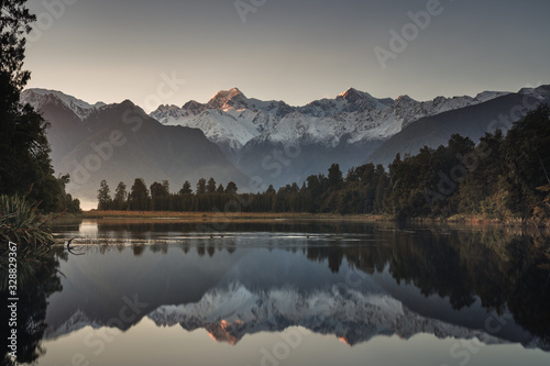 Sunrise at lake Matheson with reflection of mount Cook and mount Tasman, Fox glacier, South island, New Zealand.