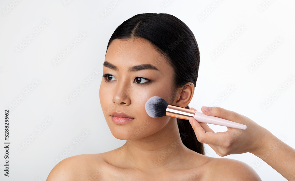 Chinese Girl Using Brush Applying Face Powder On White Background Chinese Girl Using Brush Applying Face Powder On White Background