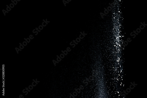 Started splash of white flour powder on black background.
