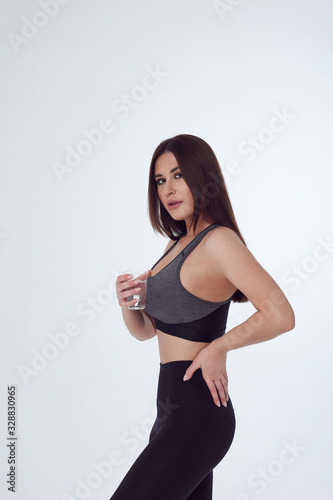 Woman in sport wear drink water from glass