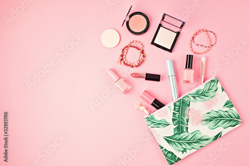 Flat lay with set of professional decorative cosmetics, makeup tools and woman spring, summer accessories over pink background with copy space. Beauty blog, fashion, party, shopping
