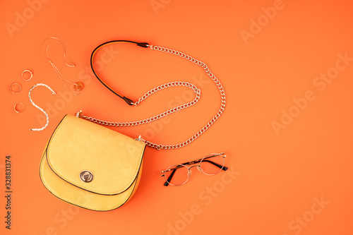 Flat lay with woman fashion accessories in yellow color over orange yellow textured background. Fashion, online beauty blog, summer style, shopping and trends idea photo