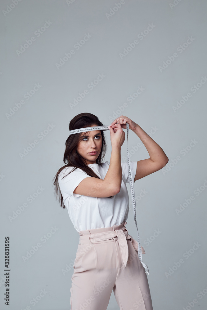 girl stands and measures her head using measuring tape girl stands and measures her head using measuring tape