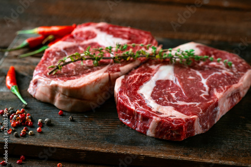 Two classic fresh rib eye steaks on a wooden Board