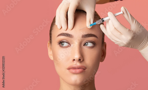 Young Woman Receiving Botox Beauty Injection In Forehead, Studio Shot photo
