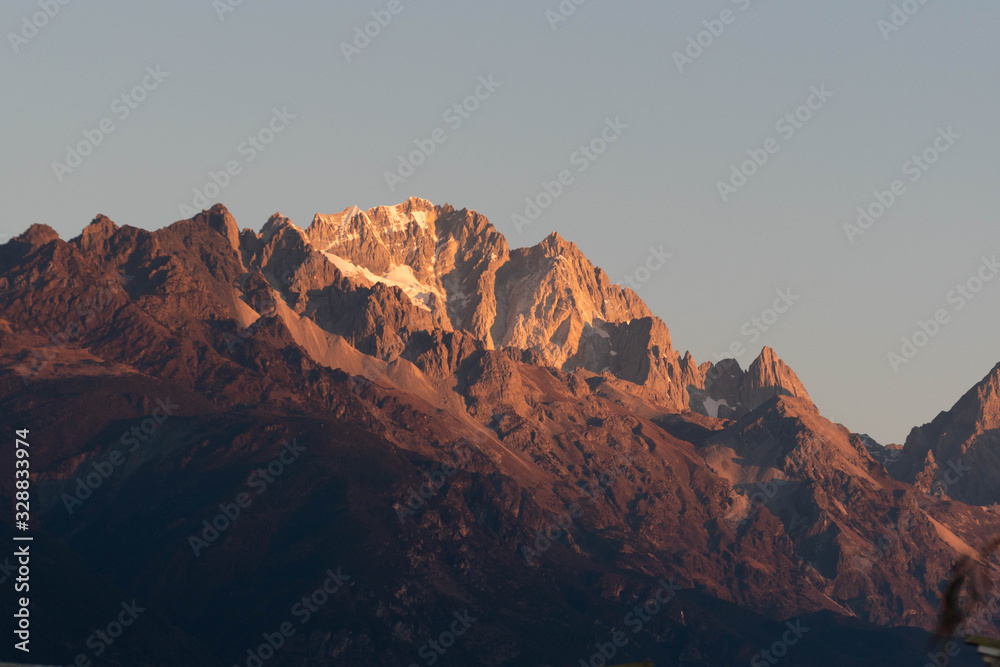 Close up of snow mountain in the early morning time, sunrise, with bright blue sky and copy space