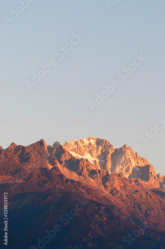 Close up of snow mountain in the early morning time, sunrise, with bright blue sky and copy space