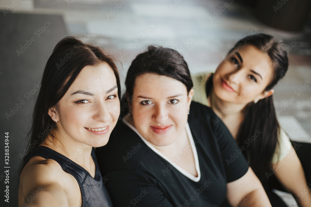 Fitness, friendship, teamwork, leisure. Group of women in gym. Sporty and active lifestyle. Females taking a break between exercising sets