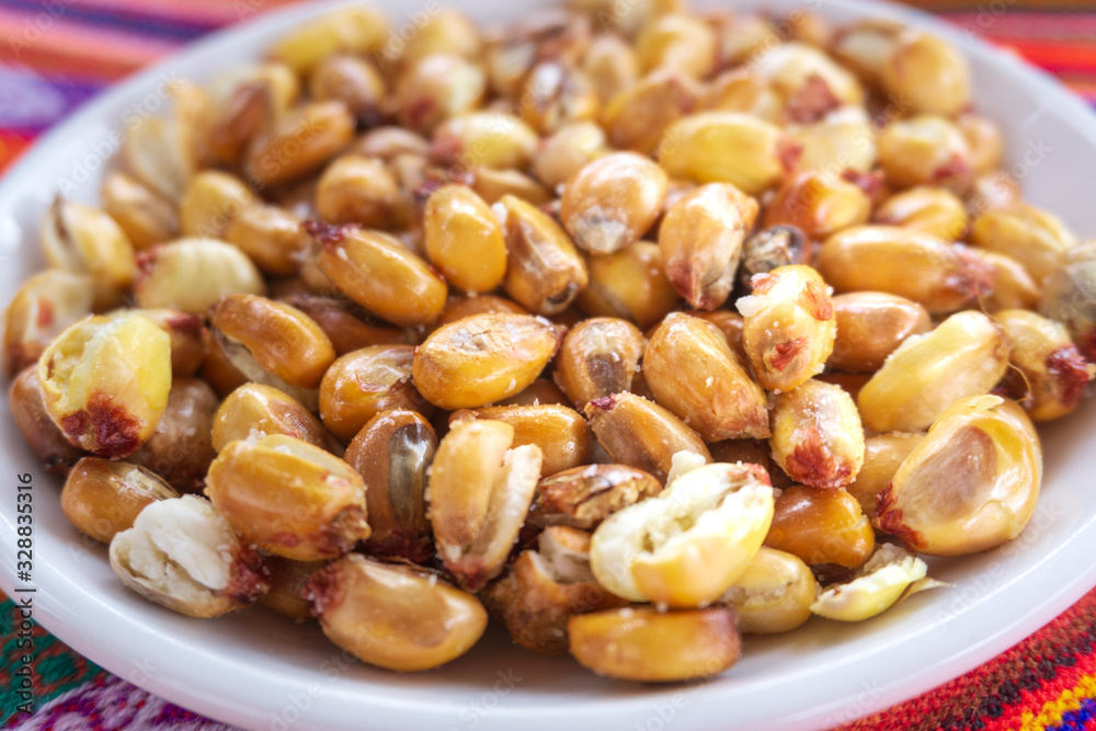 Toasted Andean corn with salt served on a white bowl Toasted Andean corn with salt served on a white bowl