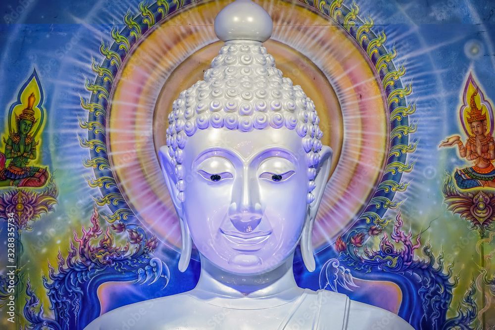 Great white Buddha statue with blue background wall.