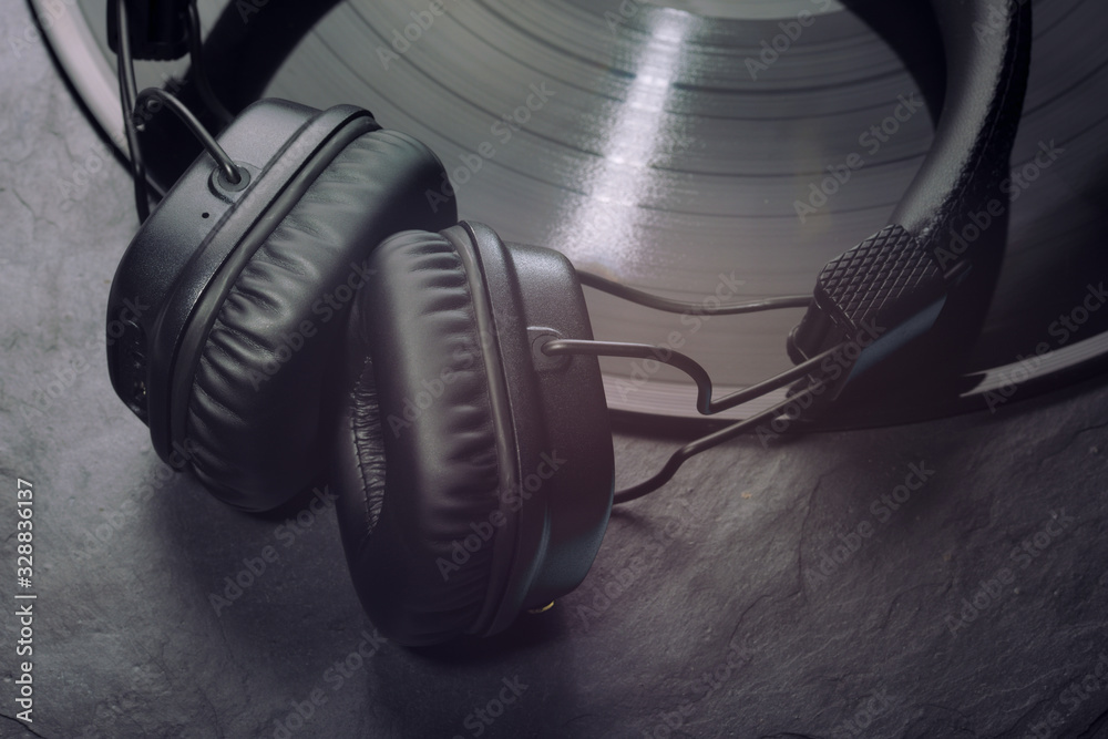 Over or on-ear headphones on vinyl record. Over or on-ear headphones on vinyl record.