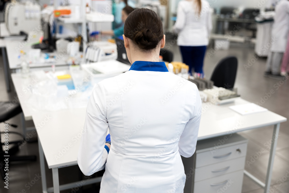 Female scientist in lab coat working in science laboratory Female scientist in lab coat working in science laboratory