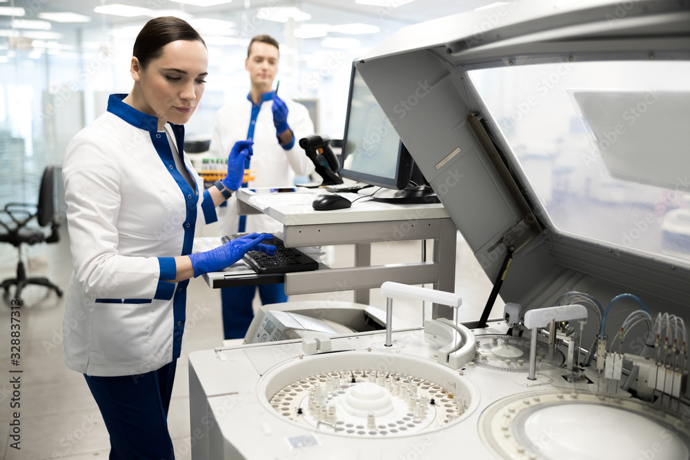 Young scientist using advia immunoassay system in lab Young scientist using advia immunoassay system in lab