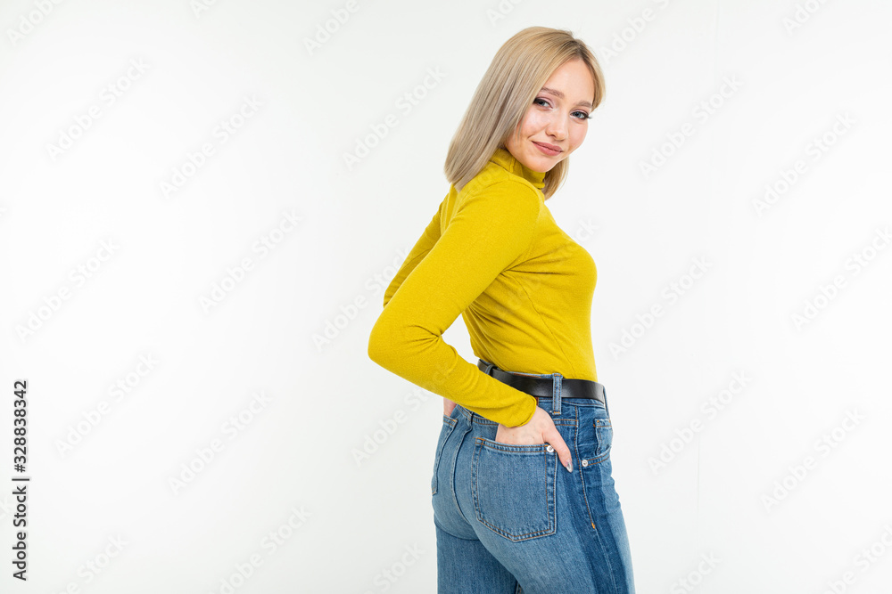 stylish girl in a lemon turtleneck and jeans posing on a white background with copy space stylish girl in a lemon turtleneck and jeans posing on a white background with copy space