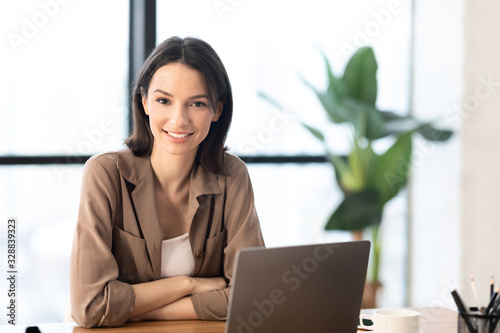 Photos Young manager smiling at camera in modern office